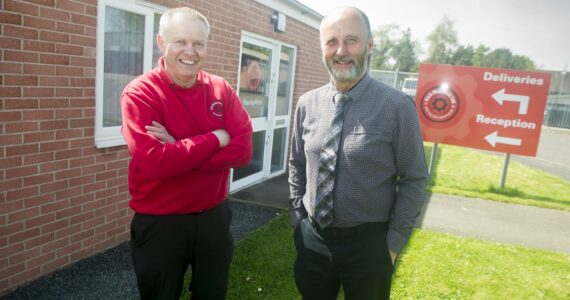 Stuart and Alastair McKenzie stood outside the front of the Distribution Centre